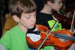 Student from Scarsdale Strings enjoying the violin!